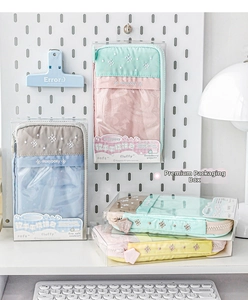 Macro view of pastel multi-compartment stationery pouch in its premium retail packaging