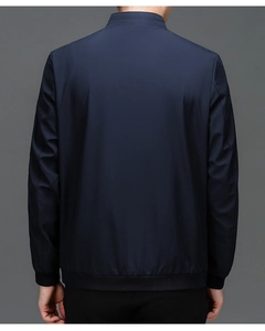 Rear view of deep blue men's jacket showing minimalist cut and black ribbed hem details