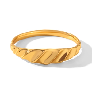 Macro detail of 18k gold plated stainless steel bracelet showing wavy textured surface