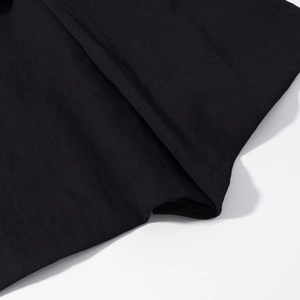 Close-up of black twill fabric texture and meticulous stitching detail on a modern jacket