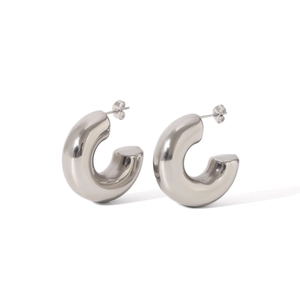 Macro shot of polished silver hollow C-shaped earrings with thick metal tube texture