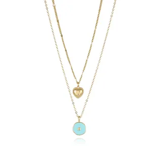 Detail of double-layer gold necklace featuring heart and blue star enamel pendants