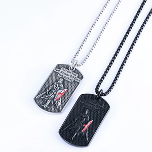 Detail of silver and black dog tag necklaces with knight relief and red cross engraving