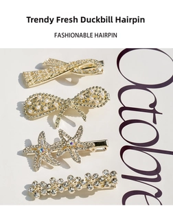 Set of four gold-tone hair clips with pearls and crystals on a minimalist background