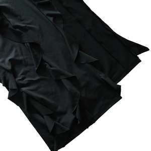 Vue détaillée de l'ourlet à volants et des coutures sur une robe noire sexy