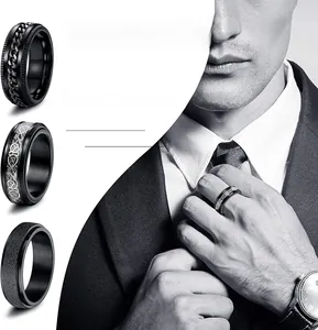 Detail of three black fidget rings featuring chain inlay, celtic knot, and matte finish