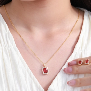 Elegant gold jewelry set with square red gemstones and crystals worn by a model