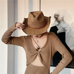 Detailed view of brown woven cowboy straw hat paired with matching knitwear top
