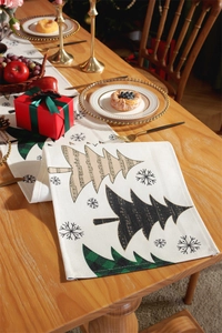 Close-up of modern Christmas table runner with festive tree patterns on a wooden table