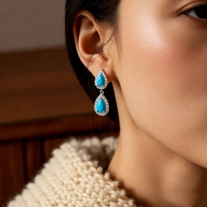 Macro shot of silver vintage drop earrings with sky blue stones and zircon pavé accents