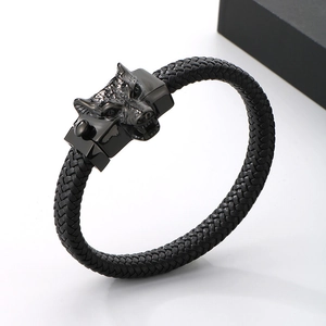Detail view of woven leather bracelet featuring a black punk style wolf head steel clasp