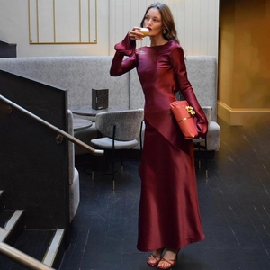 Detail of elegant burgundy satin long dress with backless design and thigh-high side slit