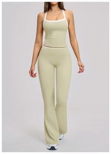 Detail van lichtgroene yogaset met witte contrastranden en uitlopende sportbroek