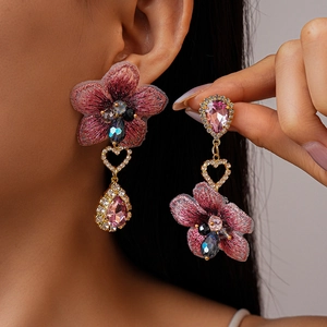 Détail de boucles d'oreilles florales roses avec strass et cristaux sur tige en argent