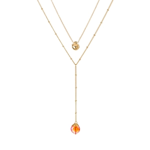 Détail d'un collier double rang doré avec pendentif en pierre rouge et breloque pois