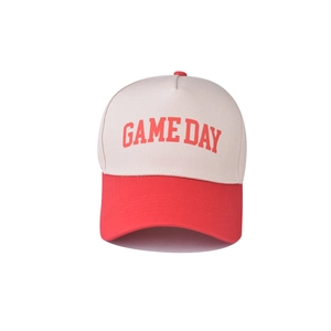 Close-up of GAME DAY print on cotton baseball cap with red brim and cream crown