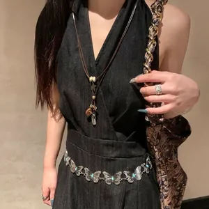 Detailed close-up of retro alloy butterfly waist chain and star feather pendant necklace
