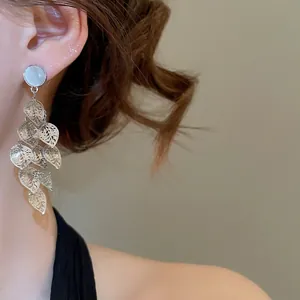 Silver drop earrings with opal stud and cascading leaf charms on model view