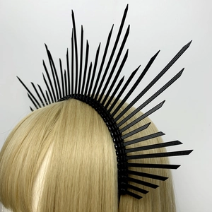 Detail of a black spiked halo headband crown accessory on a golden blonde wig
