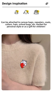 Detail of red and white heart enamel pin worn on a beige sweater for stylish accessory