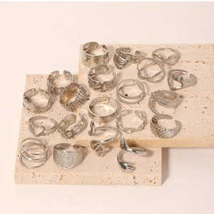 Macro shot of silver-toned stainless steel rings with heart and chain patterns on stone