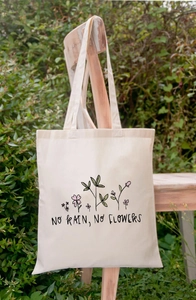 Crèmekleurige canvas draagtas met 'No Rain No Flowers' bloemenprint in natuurlijk licht