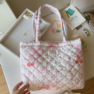 Nahaufnahme der gesteppten Baumwolltasche mit Kirschmuster und weicher Stoffstruktur