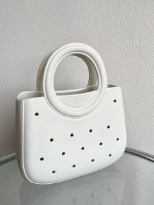 Vue détaillée d'un sac de plage blanc en EVA avec perforations et poignées rondes