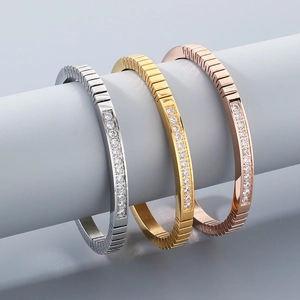 Detailed view of polished stainless steel bracelets with zircon inlay in gold, silver, rose gold