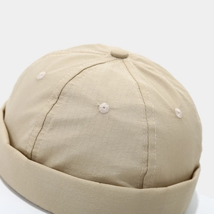 Detail view of khaki ripstop fabric docker hat with reinforced white stitching and air holes