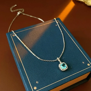 Macro detail of square blue zircon pendant necklace on luxury gift box packaging