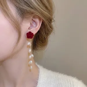 Elegant red velvet rose earrings with white pearl tassels on a vintage gold chain