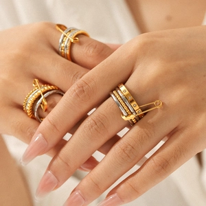 Layered gold and silver safety pin ring with cubic zirconia on model hand