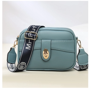Vista detallada del bolso cruzado de cuero PU verde teal con cerradura metálica y correa.