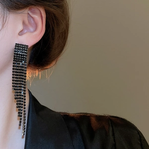 Gros plan de boucles d'oreilles à pampilles en strass noirs portées par un mannequin