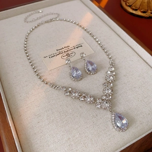 Détail du collier argenté et boucles d'oreilles en zircon violet sur un plateau