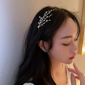 Detail view of a silver branch hairband with leaf accents on model's dark hair