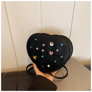 Detail of black heart-shaped bag featuring colorful rhinestones and star-shaped accents