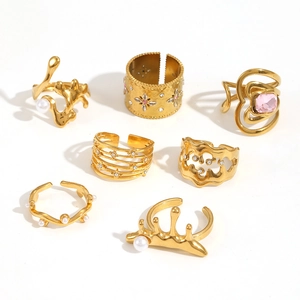 Detailed set of seven vintage hollow titanium steel gold rings with pearls and pink diamonds