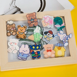 Assorted cute acrylic cartoon badges with animals in a wooden frame on yellow background