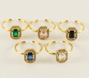 Macro detail of five-piece gold adjustable rings set with colorful rectangular crystals