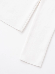 Detailed close-up of white ribbed knit fabric texture and high-quality edge stitching