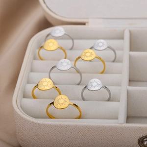 Detail of classic sun pattern gold and silver rings displayed in a luxury jewelry box