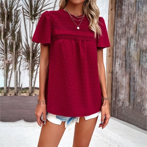 Women's red short-sleeve top with lace trim and polka dot pattern worn with denim shorts