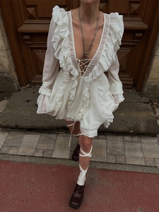 White ruffle layered long sleeve dress with deep V-neck and tie-up front design