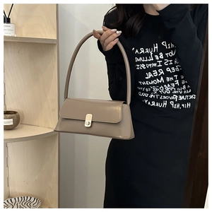 Close-up of vintage milk coffee PU leather baguette bag with a gold twist-lock closure