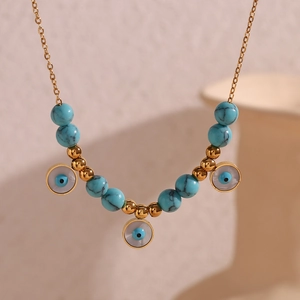Detail of 18K gold plated necklace featuring turquoise beads and evil eye pendants