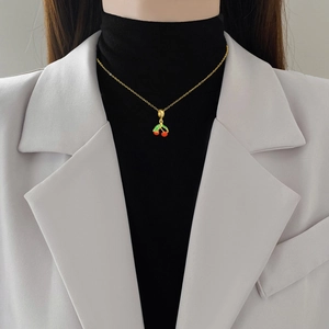 Collier cerise élégant en titane doré avec feuilles vertes et cristaux sur modèle