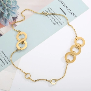 Minimalist gold titanium steel chain necklace with circular links on a modern desktop
