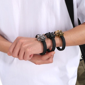 Close-up of wolf head braided leather bracelets in silver, gold, and black finishes
